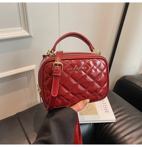 Détail du sac à main matelassé rouge en similicuir avec logo et bandoulière