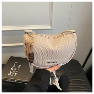 Detailed macro view of the beige mesh moon bag with MEAREY brand label and woven strap