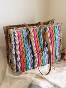 Colorful striped woven tote bag with brown leather handles for beach or travel