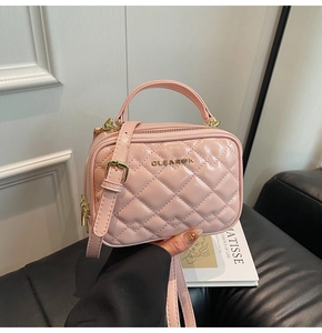 Gros plan détaillé du sac en cuir verni rose matelassé avec logo doré et fermeture éclair