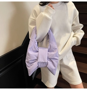 Detail shot of the lavender padded bow-shaped shoulder bag in a soft quilted texture