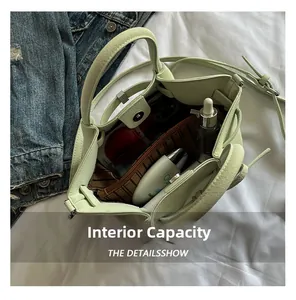Vue intérieure du sac seau vert menthe montrant la capacité pour portable et maquillage