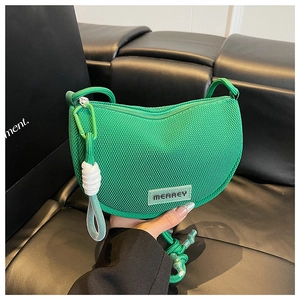 Detail of green mesh crossbody bag with climbing rope zipper pull and brand rubber label