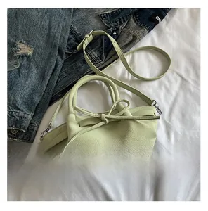 Détail du sac à main vert clair en cuir grainé avec un nœud décoratif élégant