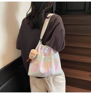 Detail of colorful plaid drawstring bucket bag with cute plush coffee cup charm