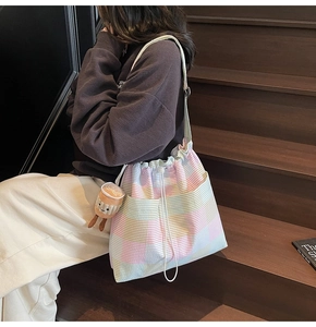 Macro detail of macaron striped tote bag featuring unique textured fabric and doll charm
