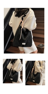 Detail of black suede tote bag featuring a ruffled strap and pink decorative drawstring