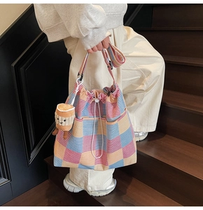 Detail of colorful striped tote bag with a cute coffee cup plush charm on the strap