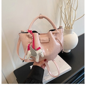 Close-up of pink stone pattern handbag with a decorative white horse charm and tassels