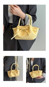 Détails du sac à main jaune en cuir grainé avec nœud décoratif et poignées solides
