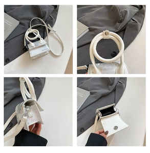 Detailansicht der Mini-Handtasche in Weiß mit Schlangenmuster und großem Ringgriff