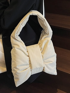 Chic padded beige hobo bag with a large bow design and soft puffer texture material