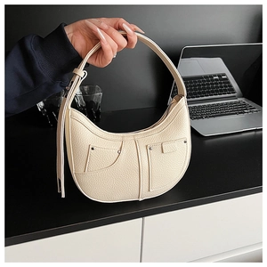 Detail der cremeweißen Halbmond-Tasche mit Lychee-Maserung und modischem Denim-Taschen-Design
