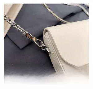 Detail view of premium silver metal hooks and chain on white lychee leather bag