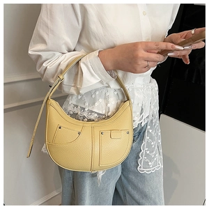 Gelbe Hobo-Schultertasche mit Litschitextur und Silbernieten in einer Lifestyle-Umgebung