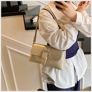 Close-up of beige oil wax leather shoulder bag with elegant silver round metal buckle