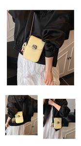 Close-up of light yellow lychee pattern leather phone bag with silver clasp and pearl bear charm