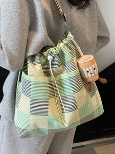 Chic striped tote bag for women with yellow and blue patterns and a cute charm