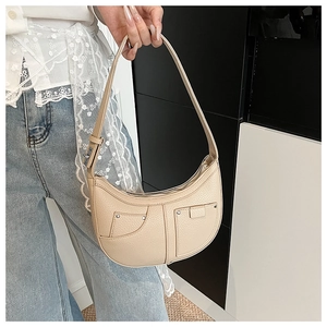 Detailaufnahme der beigen Hobo-Tasche mit Lychee-Ledertextur, silbernen Nieten und Verschlüssen