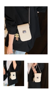 Detail of beige litchi grain phone bag featuring silver metal buckle and chain strap