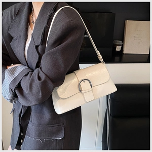 Detail showing the white glossy oil wax leather bag with its large silver metal buckle