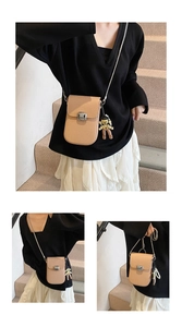 Detail of lychee pattern leather crossbody phone bag with chain strap and astronaut charm