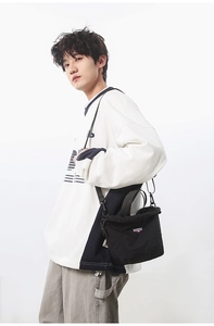 Man wearing a black nylon drawstring crossbody bag with adjustable straps for daily commute