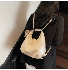 Détail du sac hobo en similicuir blanc cassé avec breloque ours et fermeture éclair