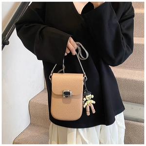 Detail of lychee pattern leather crossbody bag with silver clasp and chain strap