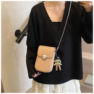 Detail view of lychee pattern crossbody phone bag with silver metal lock and cute charm