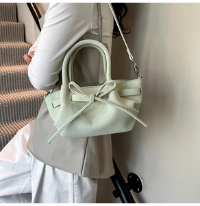 Détail d'un sac à main vert menthe avec grand nœud décoratif et texture en cuir