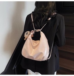 Détail d'un sac hobo rose clair en similicuir souple avec porte-clé peluche lion mignon
