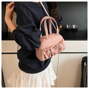 Détail du sac polochon plissé rose montrant la boucle rotative et la texture fine
