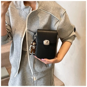 Close-up of black lychee texture crossbody phone bag with silver buckle and chain strap