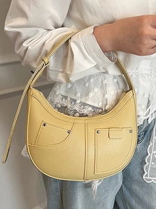 Hellgelbe Achseltasche in Halbmondform mit Lychee-Muster, silbernen Nieten und Trageriemen