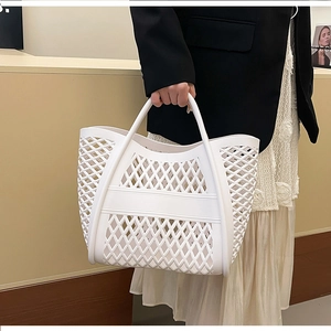Close-up of a white hollow woven rubber tote bag with modern grid texture on a model
