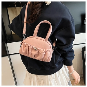 Sac polochon plissé rose avec fermoir argenté et bandoulière porté en bandoulière