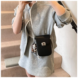 Detail of black litchi grain leather phone bag with silver buckle and pearl charm