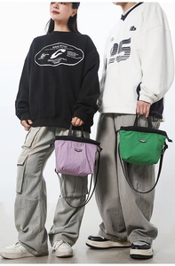 Detail of lightweight nylon crossbody bag with drawstring closure and contrast handles
