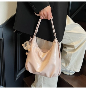 Détail du sac hobo rose clair brillant orné d'un joli pendentif en ours en peluche