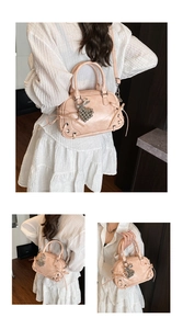 Detailansicht der rosa Boston Bag mit Schleife und Herzanhänger am Modell getragen