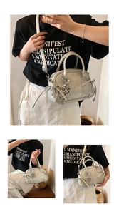 Detailansicht der Mini Boston Tasche mit seitlicher Kordel und Kugelanhänger Deko