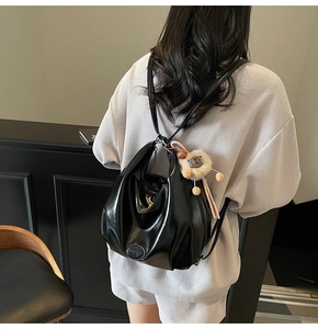 Détail du sac à dos en cuir noir souple avec pendentif lion et bretelles réglables