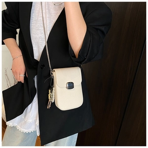 White lychee pattern crossbody phone bag with pearl charm on a black blazer model