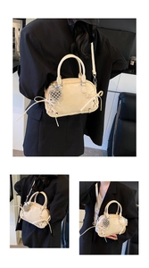Detailansicht der cremefarbenen Boston Bag mit Schleife und silbernem Herzanhänger