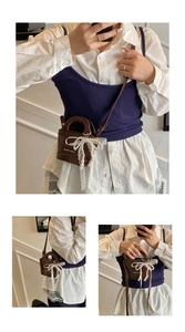Detail of a brown mini bucket bag with a white lace bow and pearl charm ornament