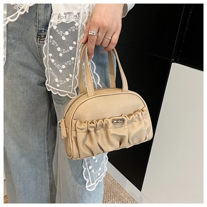 Détail de la pochette beige plissée avec fermoir rotatif en métal argenté