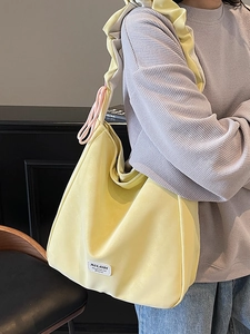 Minimalist light yellow tote bag with wide pleated strap and pink drawstring detail