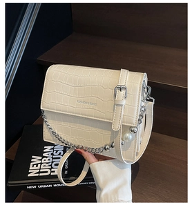 Detail of cream faux crocodile shoulder bag with pearl silver chain and leather strap