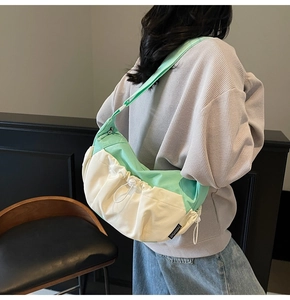 Detail of mint green and white contrast dumpling bag with adjustable shoulder strap